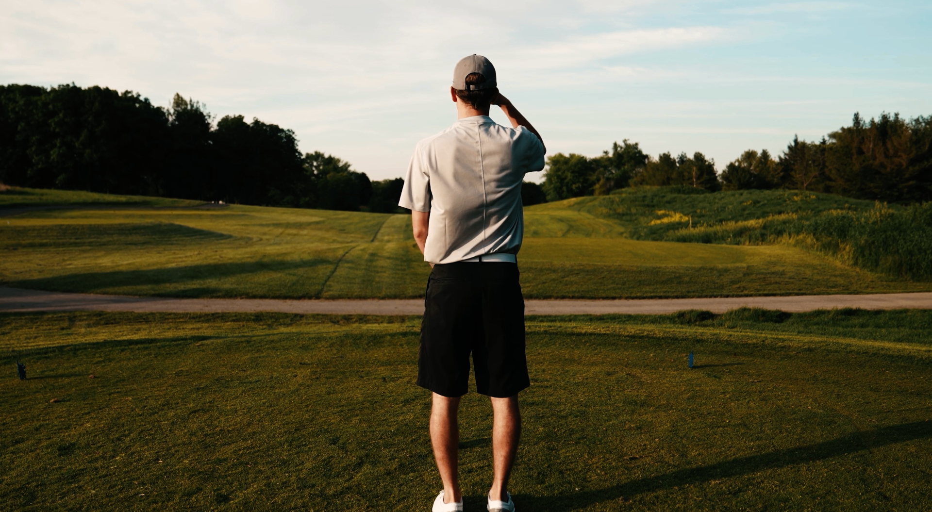 Golfer standing on the tee at golden hour