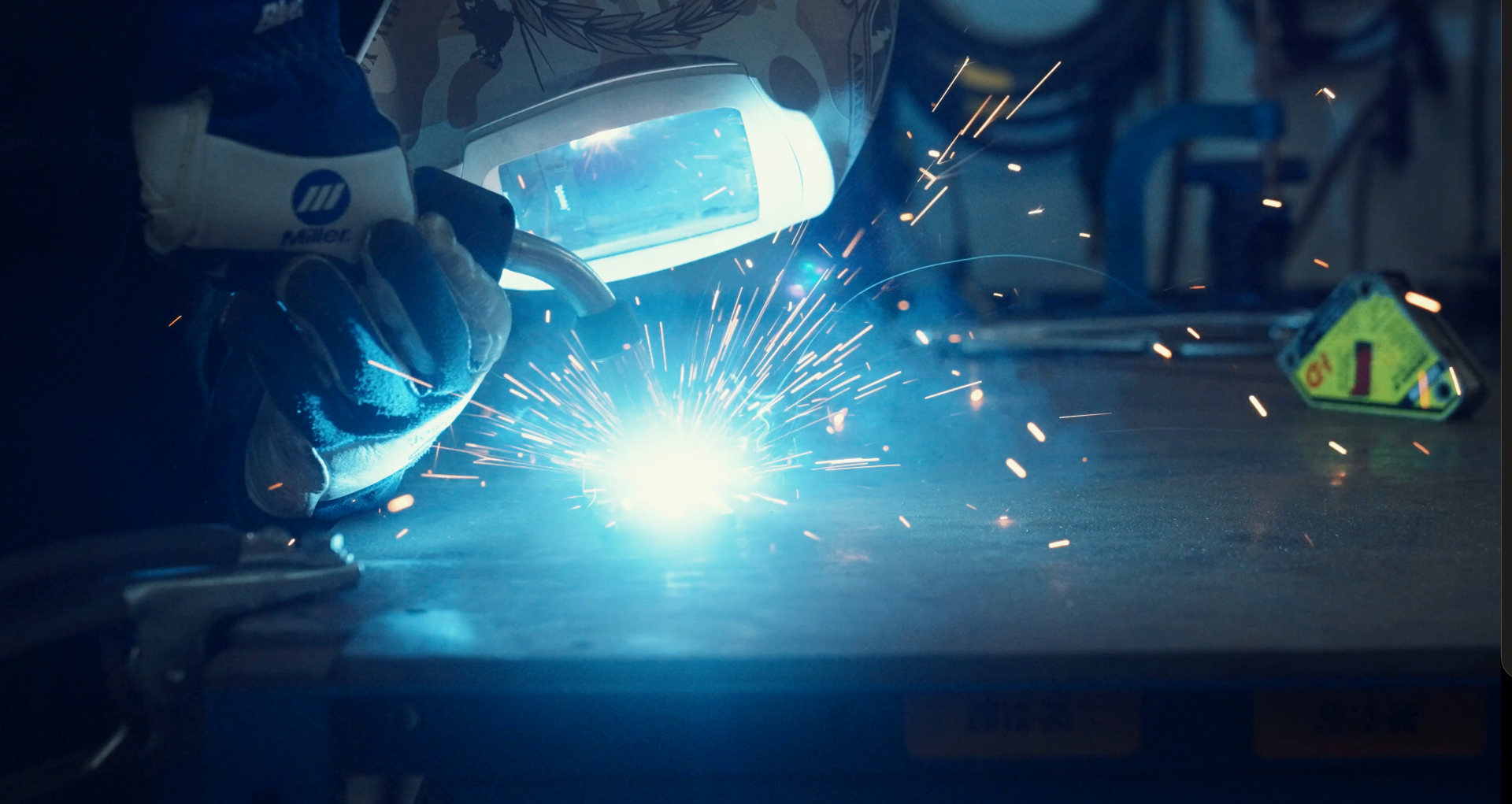 Welder striking an arc on a fabrication bench